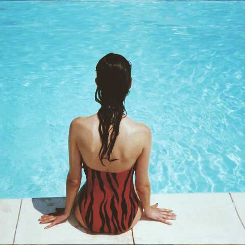 Girl sitting beside a pool